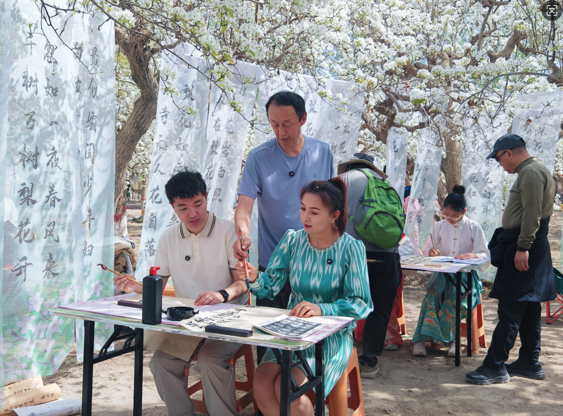 游客漫步花海体验写书法 （黄万里 摄）