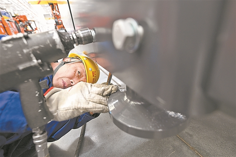 工人聚精会神地检查工程设备关键零部件组装情况,确保产品质量。