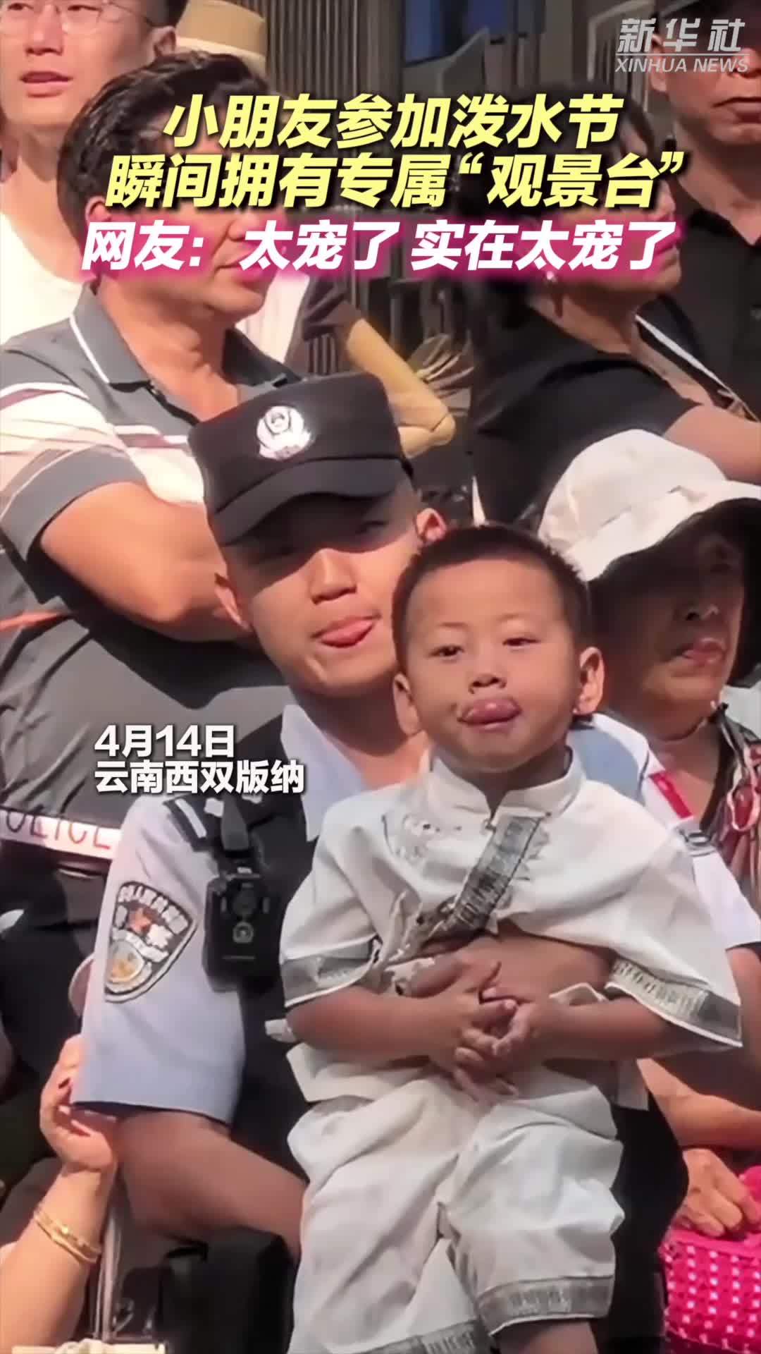 小朋友坐到警察叔叔的手臂上，瞬间拥有泼水节全场最暖“观景台”