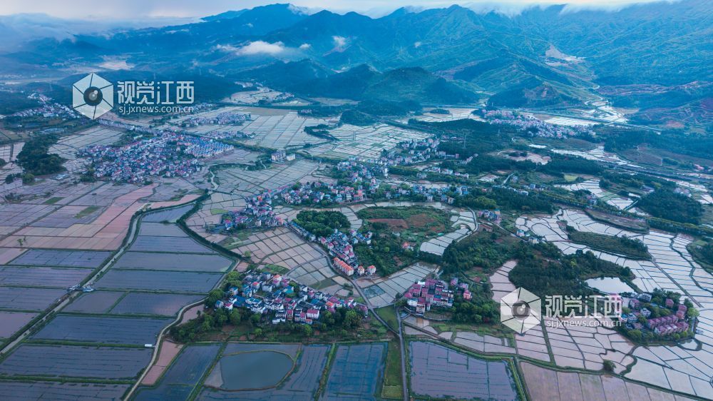 2026年4月14日，江西省吉安市吉水县醪桥镇沿江路雨停过后，远处的山脉积云成型，田野中的水面像一排排镜子，井然有序，被田野包围的小镇生动形象地展现出江西新农村的一张名片。