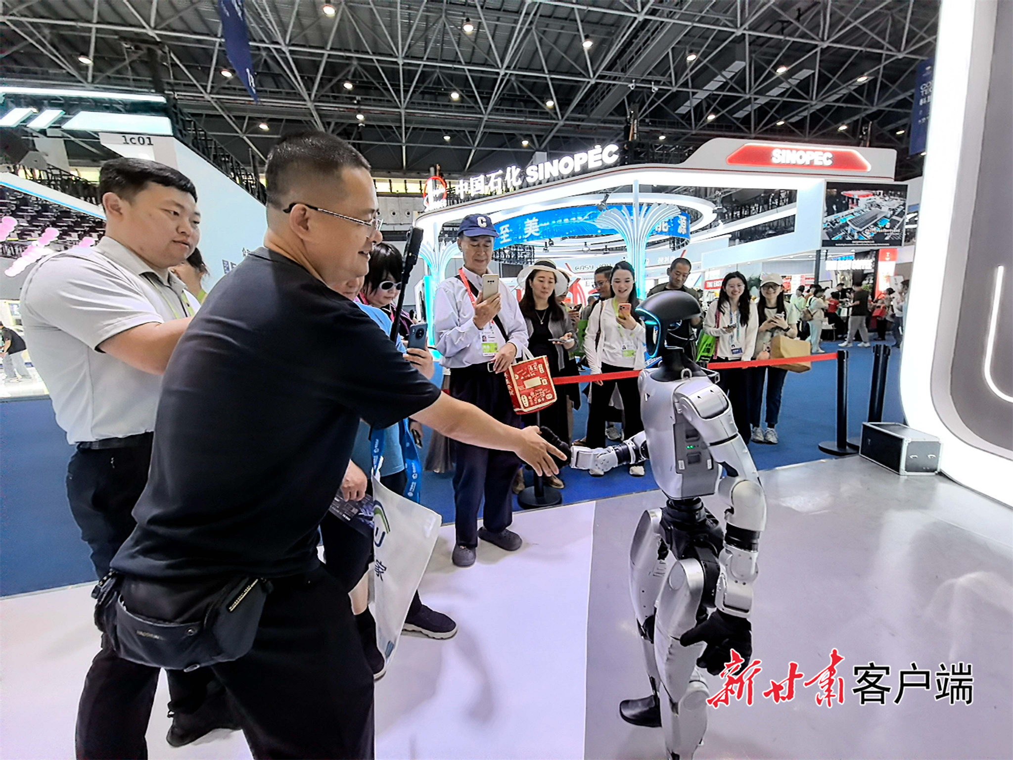 一位参观者与宇树人形机器人握手