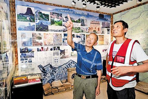 2024年7月11日，李凤鸣（左）、李勇父子俩在“长城乌字号保护站”交流。2015年，李勇从父亲手中接下接力棒，开始守护长城。 本报资料片