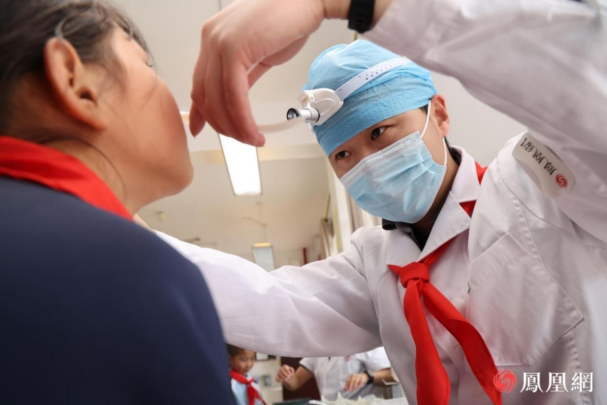 北京同仁医院医疗志愿者陈彪正在为孩子进行检查