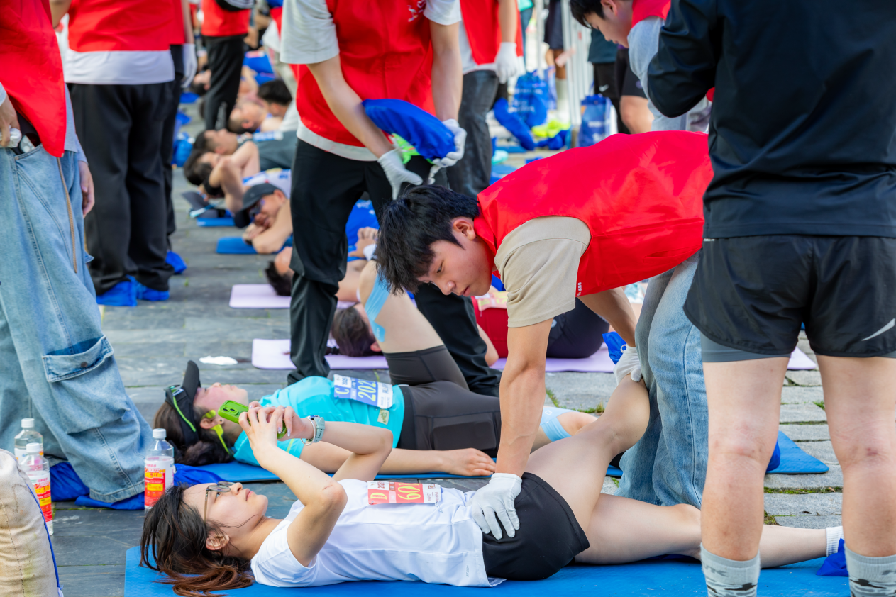 志愿者正在为完赛选手进行拉伸按摩(周珉 摄)