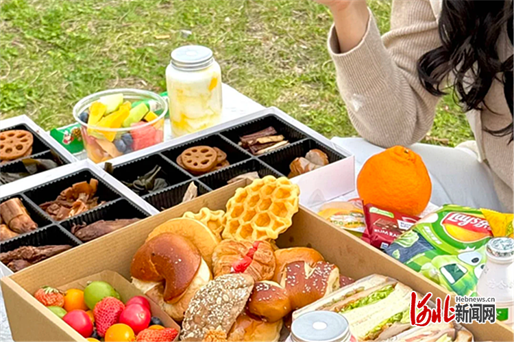 图为在滹沱河一处露营地，市民正在享用“云瑧瑧禧悦”新推出的露营餐盒。记者李瑾/摄