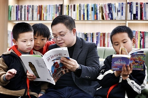 4月2日，在位于万载县鹅峰乡的文宇阁书院，创办人袁宇（右二）和前来借阅书籍的孩子们分享历史故事。本报全媒体记者 徐铮摄