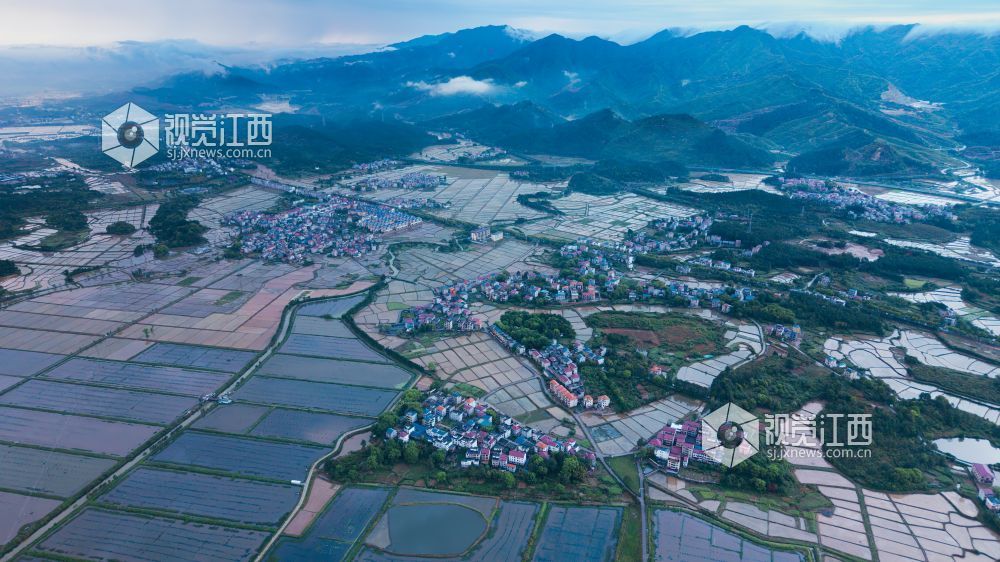 2026年4月14日，江西省吉安市吉水县醪桥镇沿江路雨停过后，远处的山脉积云成型，田野中的水面像一排排镜子，井然有序，被田野包围的小镇生动形象地展现出江西新农村的一张名片。