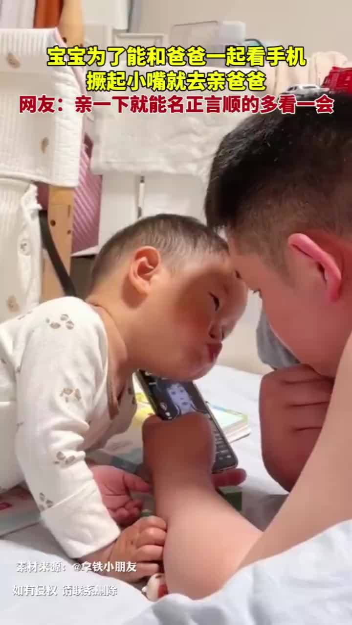 宝宝为了看手机撅嘴亲爸爸