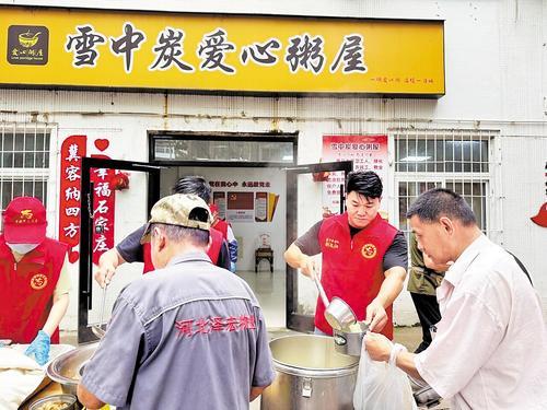 2025年5月，刘文江（右二）在雪中炭爱心粥屋做志愿服务。 本报资料片
