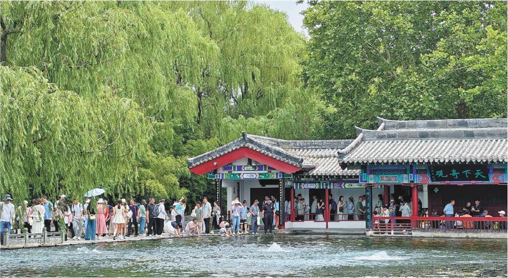 2025年6月1日，在济南明水古城景区，游客在观赏梅花泉。新华社发