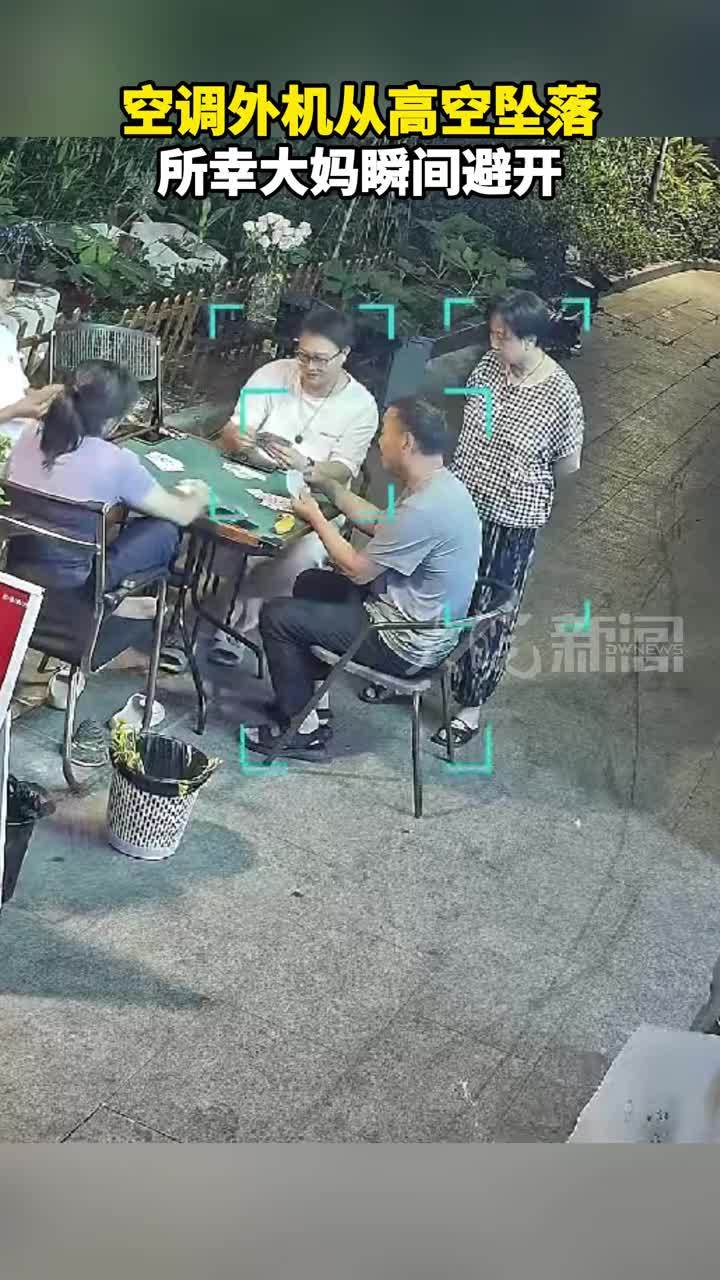 空调外机从高空坠落，所幸大妈瞬间避开