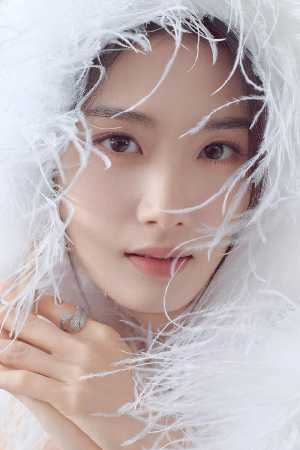 卢昱晓裹羽毛，眉眼灵动。