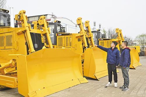 4月13日，河北宣工技术人员介绍推土机产品功能。本报记者 郭晓通摄