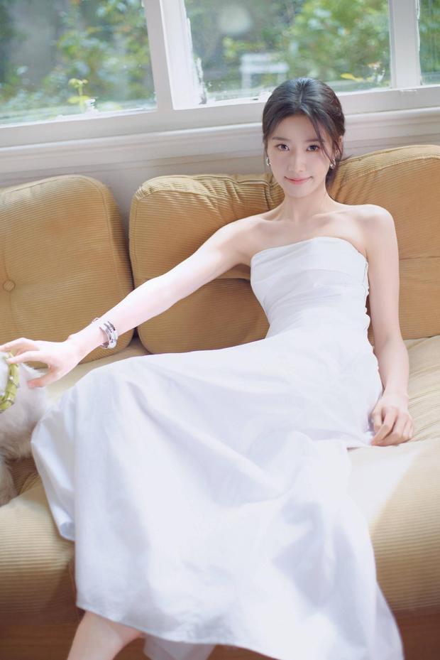 卢昱晓坐沙发逗宠，笑容清甜。