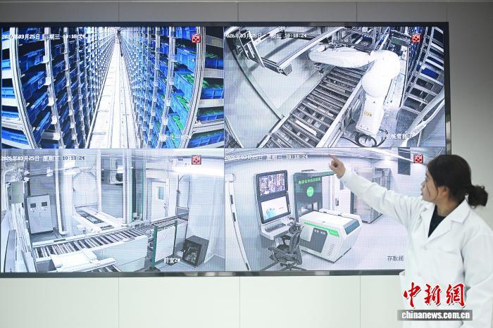 3月26日,在位于甘肃省定西市陇西县的国家药用植物种质资源库甘肃库智能库内,工作人员通过屏幕展示自动化存取设备存取种子过程。李亚龙 摄