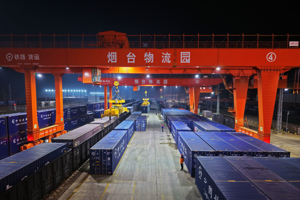 △4月10日，在济铁烟台物流园，铁路集装箱班列在进行装车作业（无人机照片）。