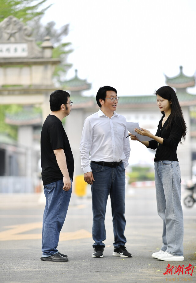 张福清（中）为湖南日报全媒体记者解联。