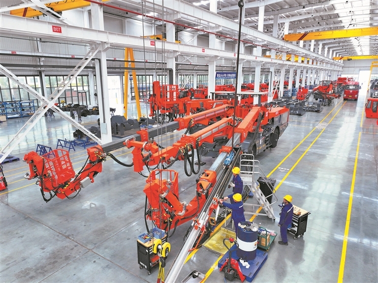 位于萍乡经开区的江西鑫通机械制造有限公司,机械臂精准挥舞,智能设备有序运转,工人正在调试出口海外的工程机械。