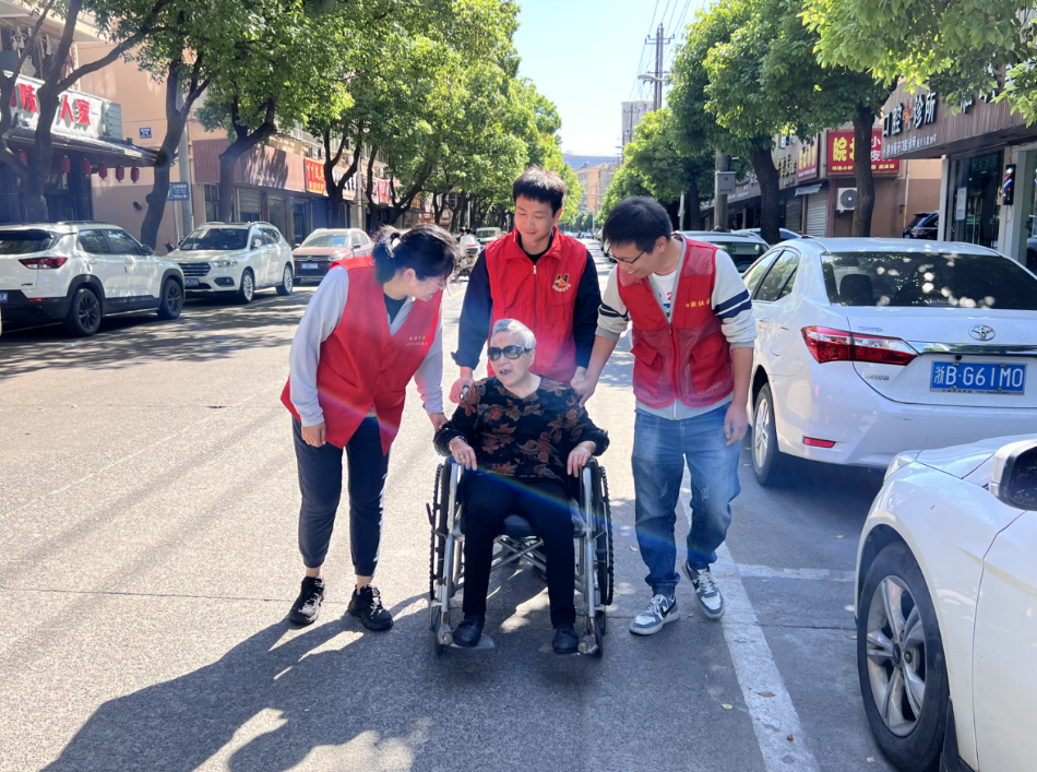 志愿者将腿脚不便的老人送医 社区供图