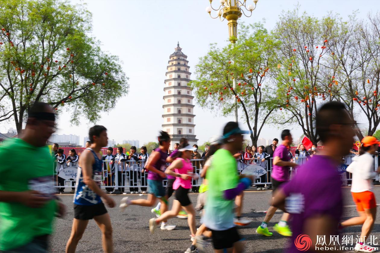 一边是千年古塔的静谧庄严，见证着岁月的流转；一边是马拉松健儿的活力奔涌，展现着城市的现代律动。古今在这一刻完美同框，跑者们用汗水与坚持，为这座历史文化名城注入了蓬勃的生机与热情。李卓然摄