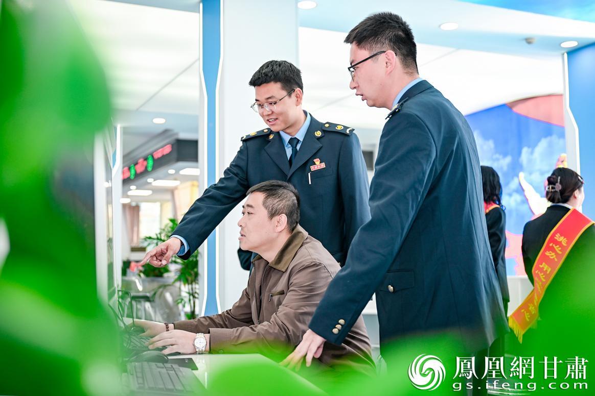 国家税务总局临洮县税务局办税服务厅内，税务人员贴心地帮助纳税人办理业务。