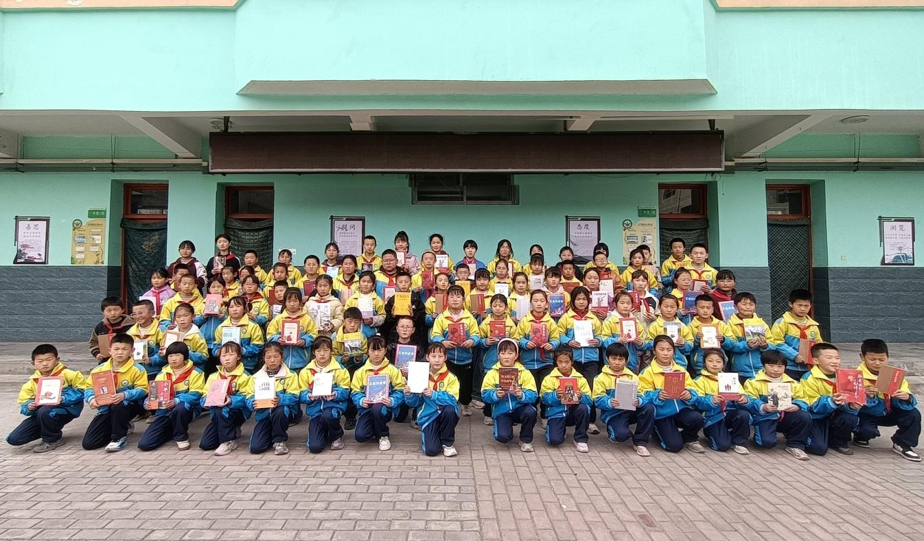 临洮县龙门镇东二十铺小学的学生们展示收到的“微心愿”图书（临洮县委宣传部供图）