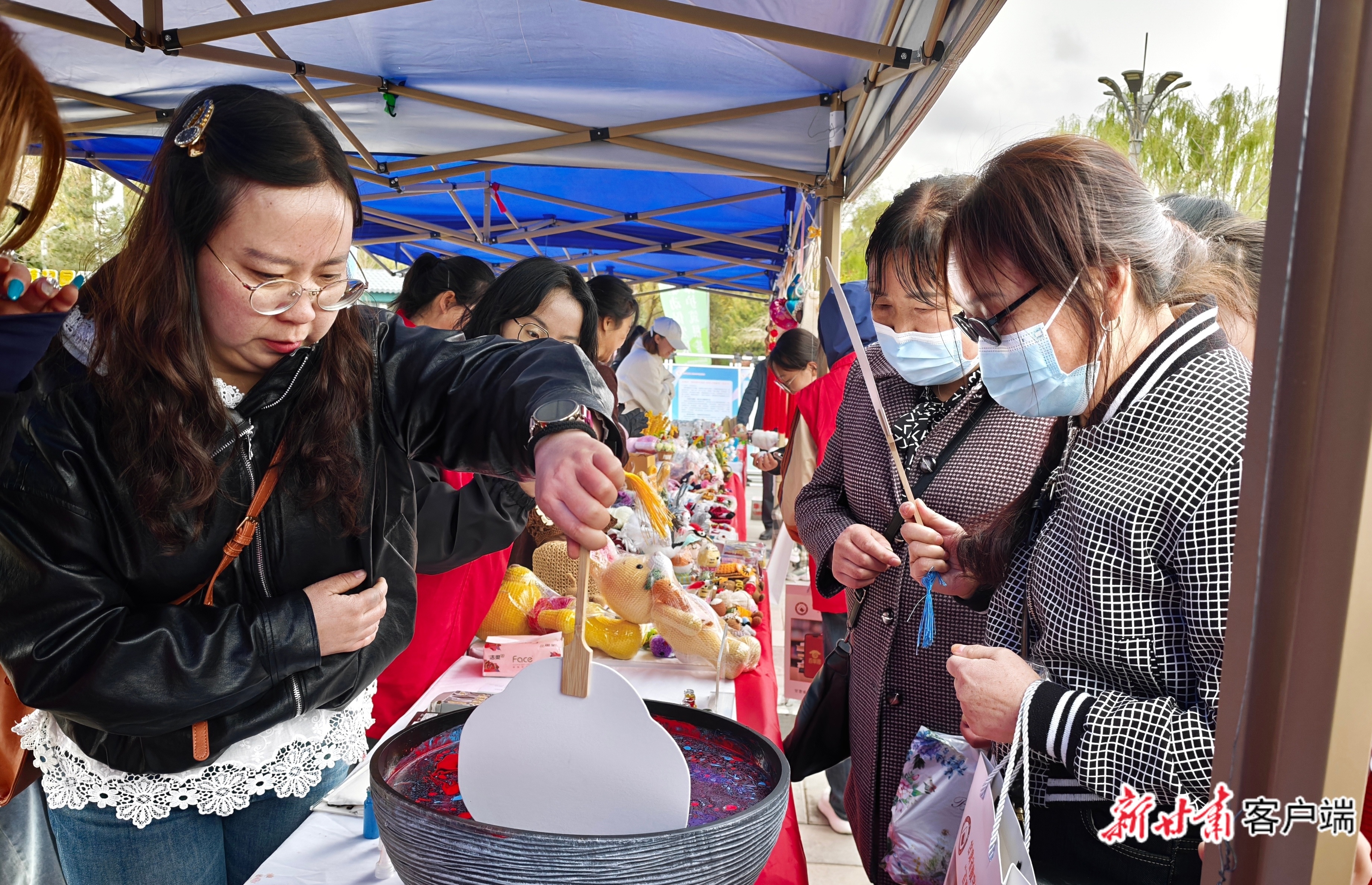 非遗展示区，工作人员展示漆扇制作。