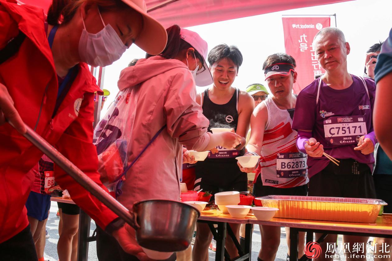 赛事期间，定州为跑者提供了羊杂汤、八大碗、烧饼夹肉等30余种地方特色美食，完赛区的美食摊前很快排起了长队。李卓然摄