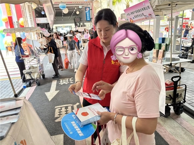 (工作人员为市民讲解金融知识)