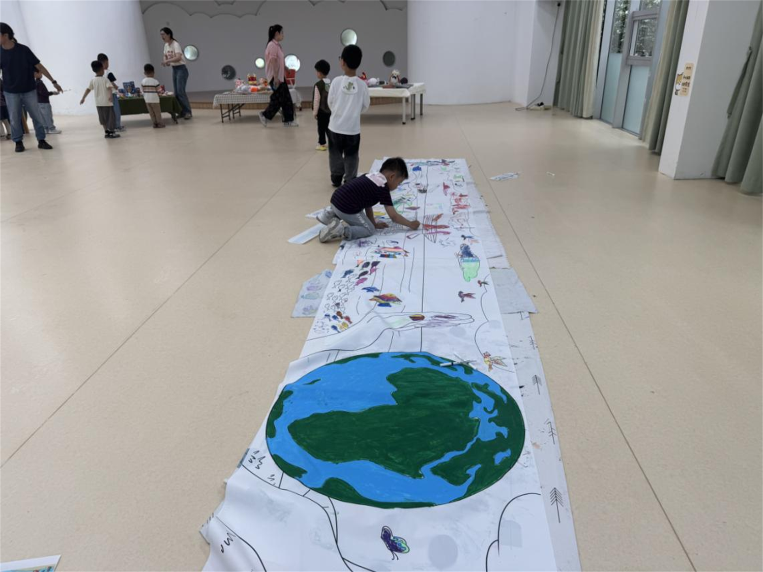 图为钟公庙社区组织孩子们绘画地球的笑脸