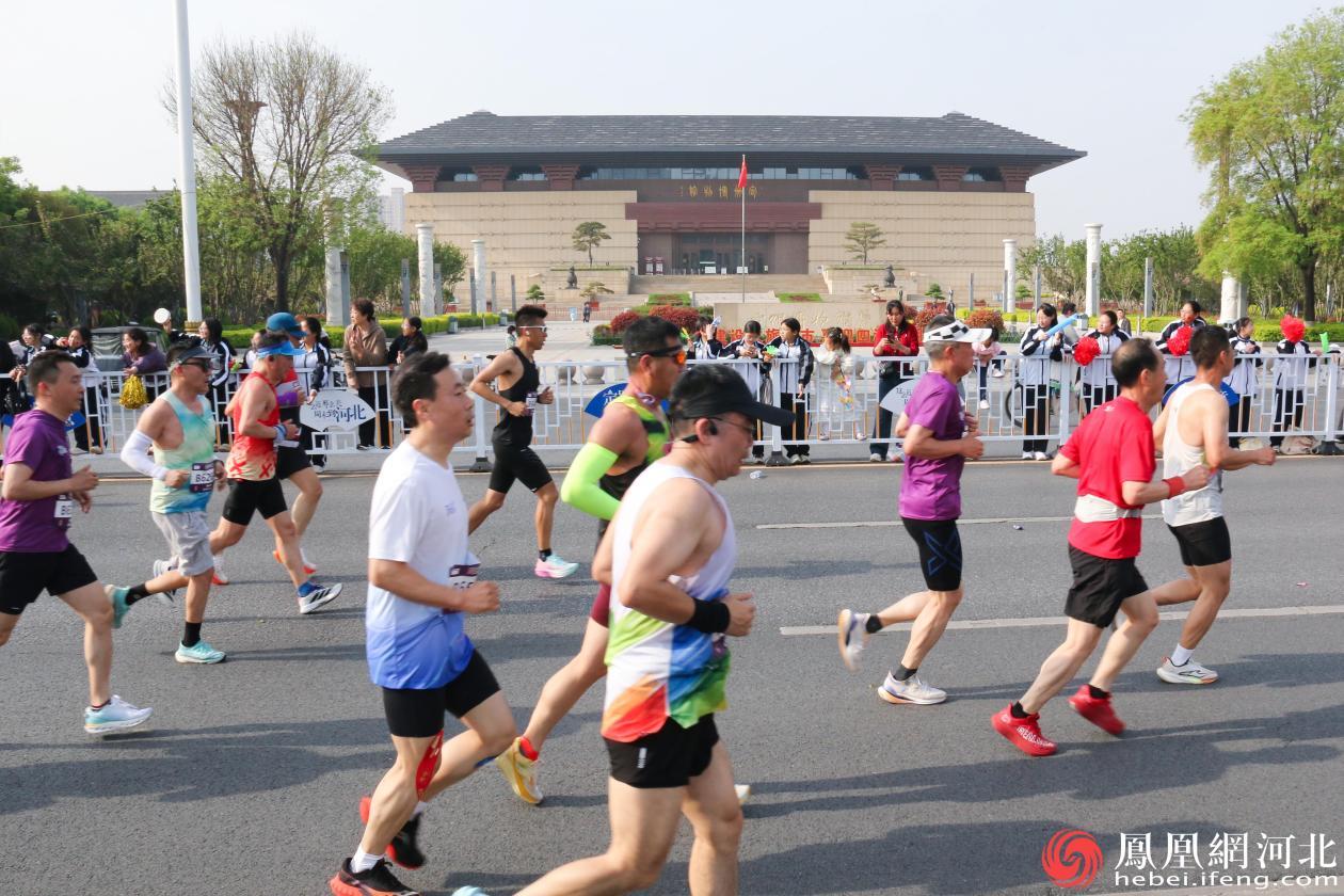 赛道旁，气势恢宏的定州博物馆如一座时光宝盒静候着跑者们的到来。镜头定格处，选手们正从博物馆前疾驰而过，现代建筑线条与矫健身姿交相辉映。李卓然摄