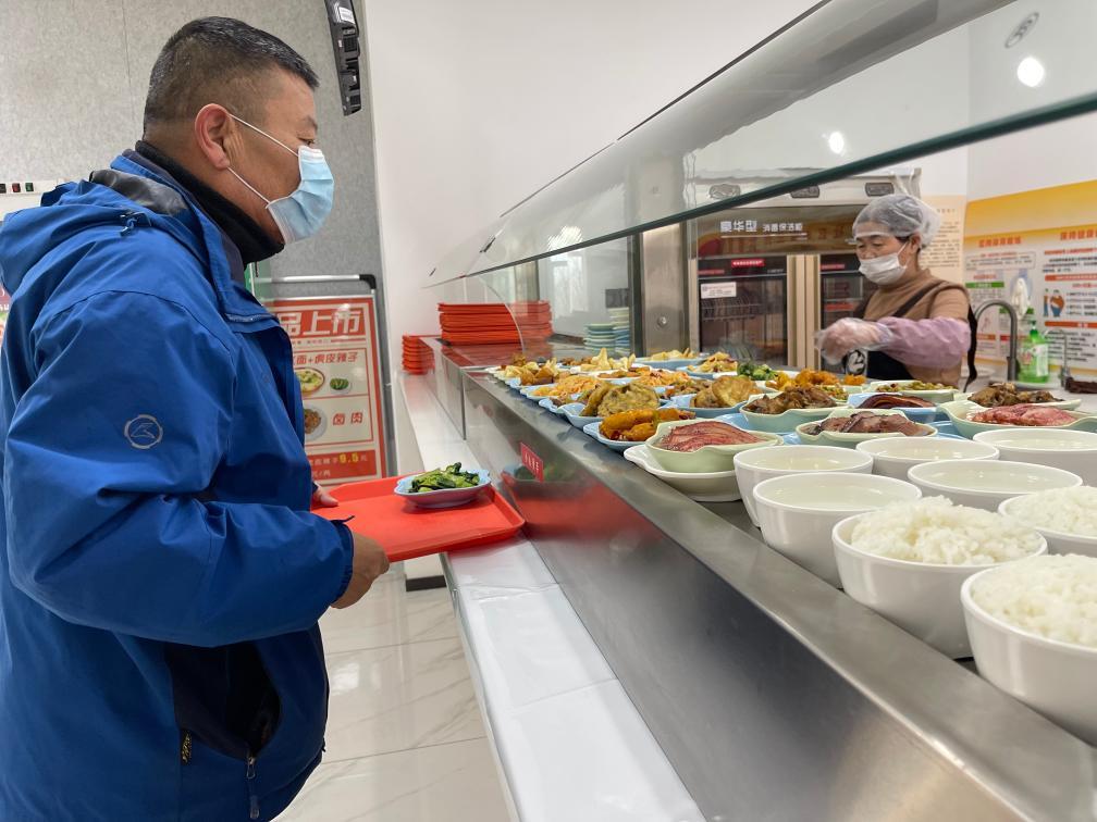 1月23日，居民在兰州市安宁区安宁西路街道枣林西社区的幸福食堂打饭。新华社记者　程楠　摄