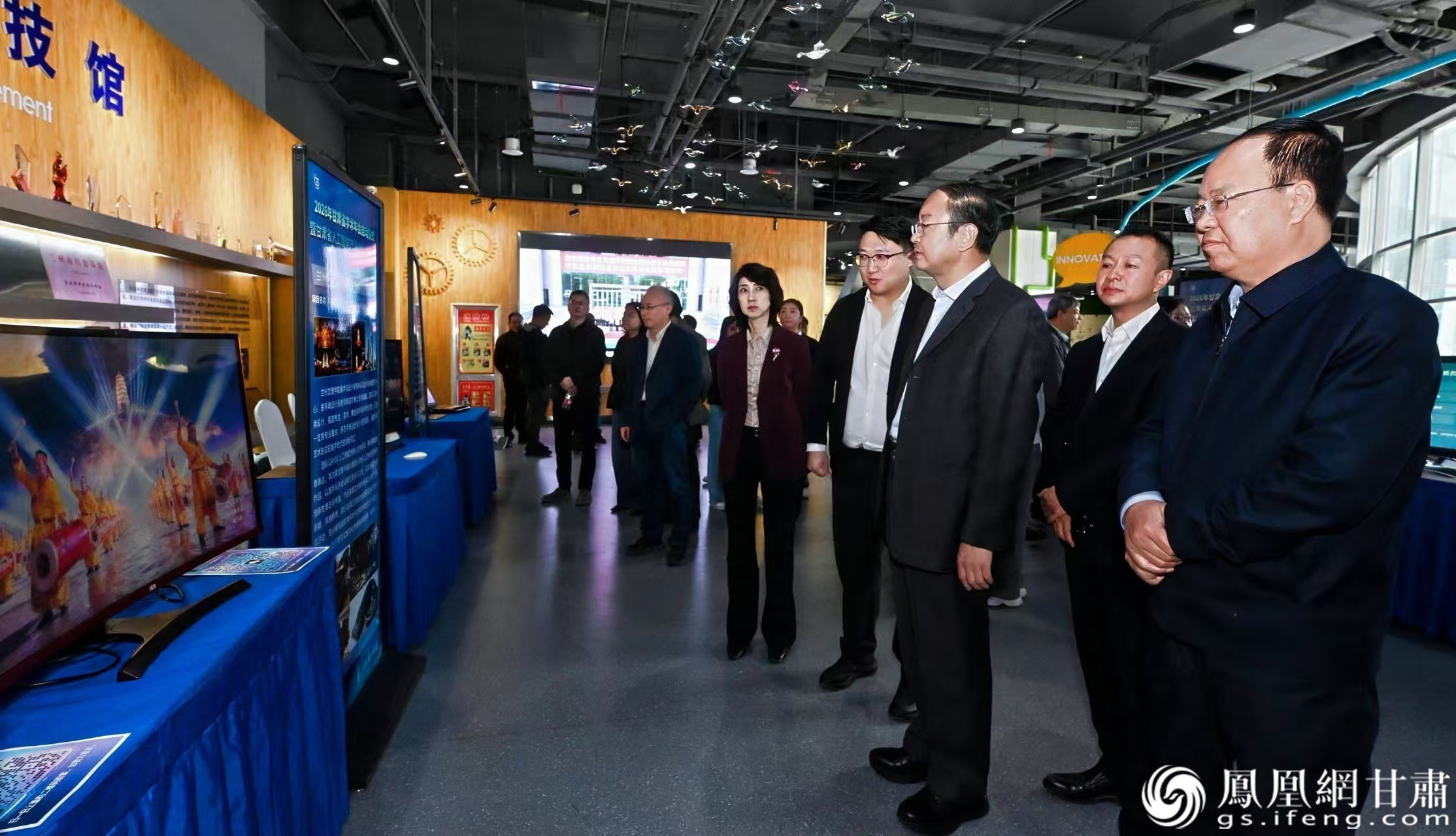 张强（右一）观看高校运用人工智能生成的甘肃地域文化作品　杨艺锴 摄