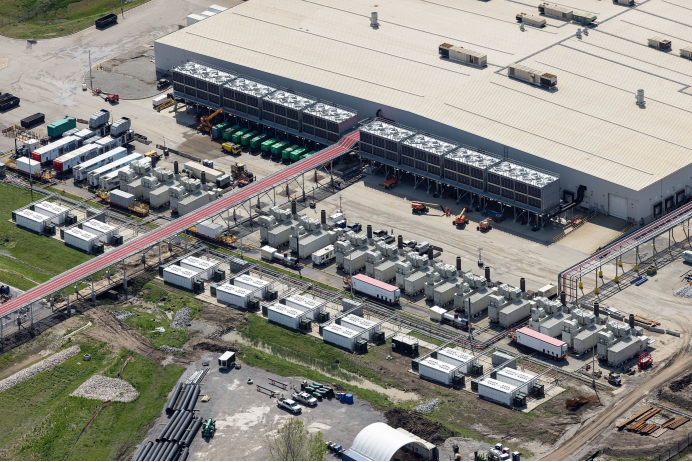 图注：Colossus 1全景航拍：大型白色厂房建筑群，停车场和周边工业区｜Action News 5