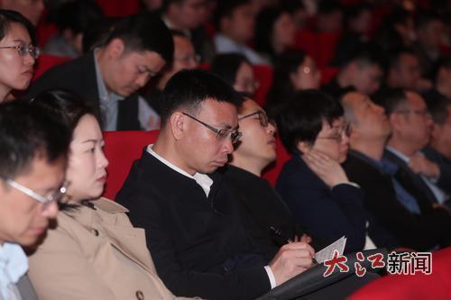 现场观众凝神听讲座、记笔记。