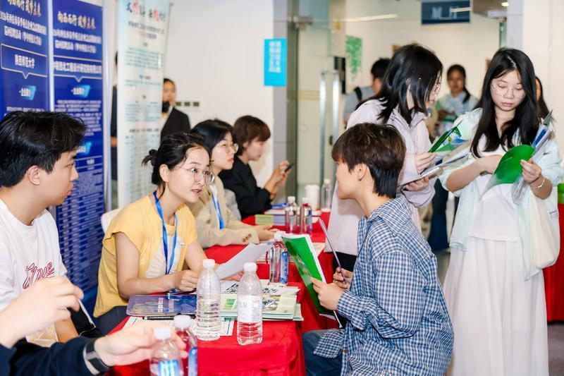 （图为 招聘会现场，求职者向西安的用人单位了解招聘信息。）