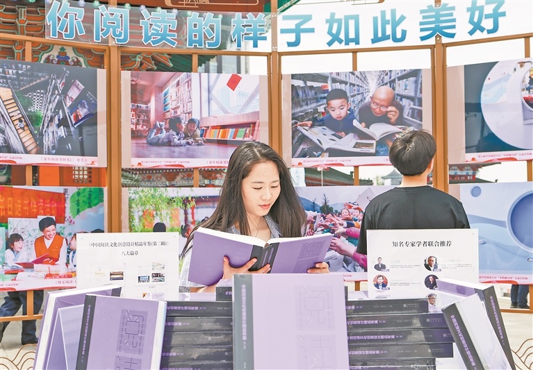 在第五届全民阅读大会活动之一的“书香满中国”公益宣传展展区，市民在阅读书籍。本报全媒体记者 田 野摄