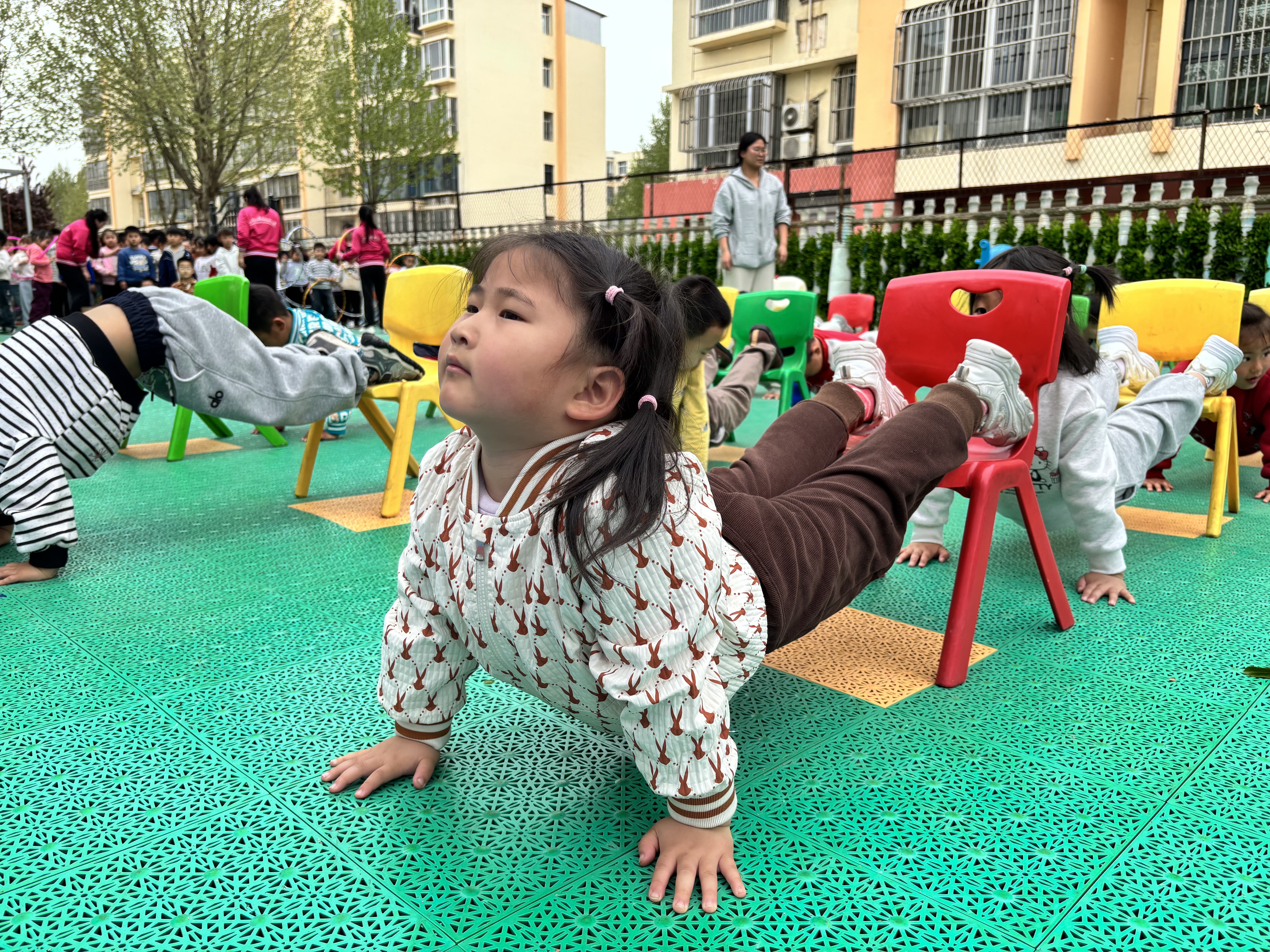 郑口蓝天迎瑞幼儿园的保育师正在为幼儿开展户外体能训练课。 魏晓培 摄