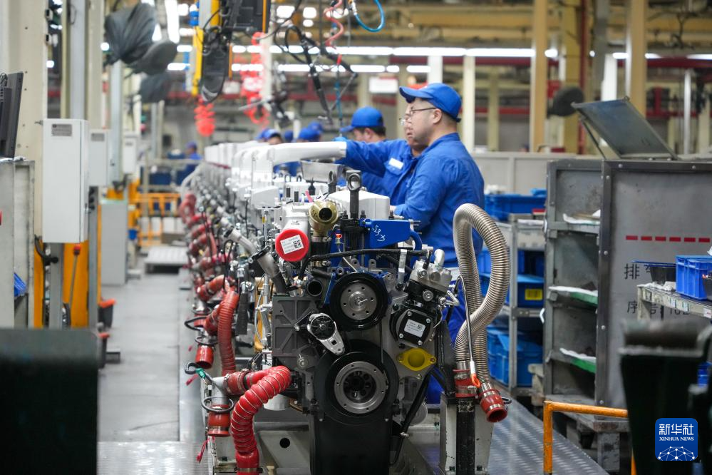 在潍柴动力总装车间，工作人员在发动机生产线作业（3月27日摄）。新华社记者 徐速绘 摄