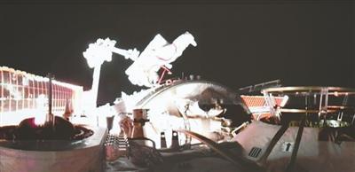 在北京航天飞行控制中心屏幕上拍摄的陈中瑞在空间站组合体舱外工作画面。