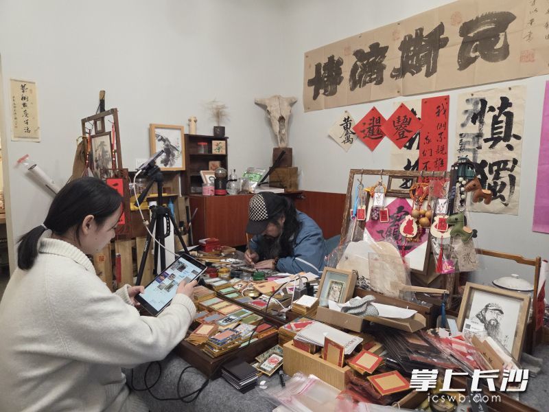 小范（左）负责线上顾客沟通，周围（右）负责冰箱贴绘制。