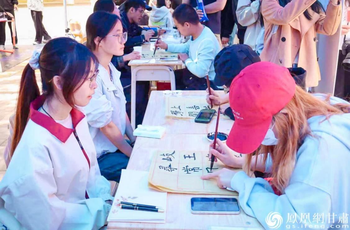 西北师范大学学子在文化传习体验市集上展示书法功底