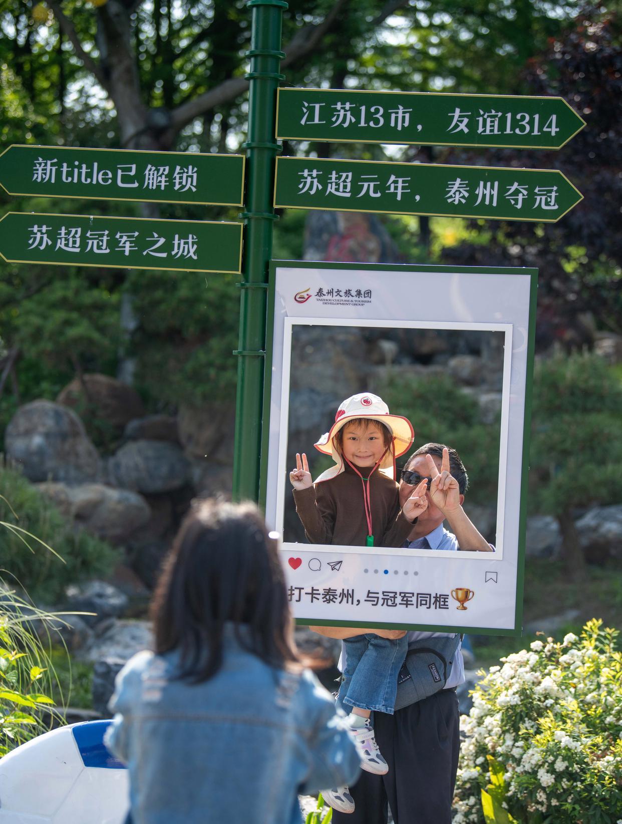 5月1日，游客在泰州市老街景区苏超标识旁打卡拍照。新华社发（杨玉岗摄）