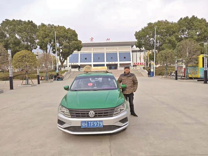袁军波和他驾驶的鄂HTF979出租车 通讯员供图