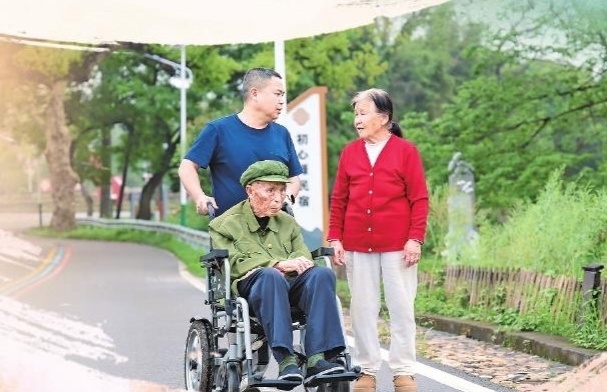 郭世训夫妻和儿子郭小华在一起聊从军往事。