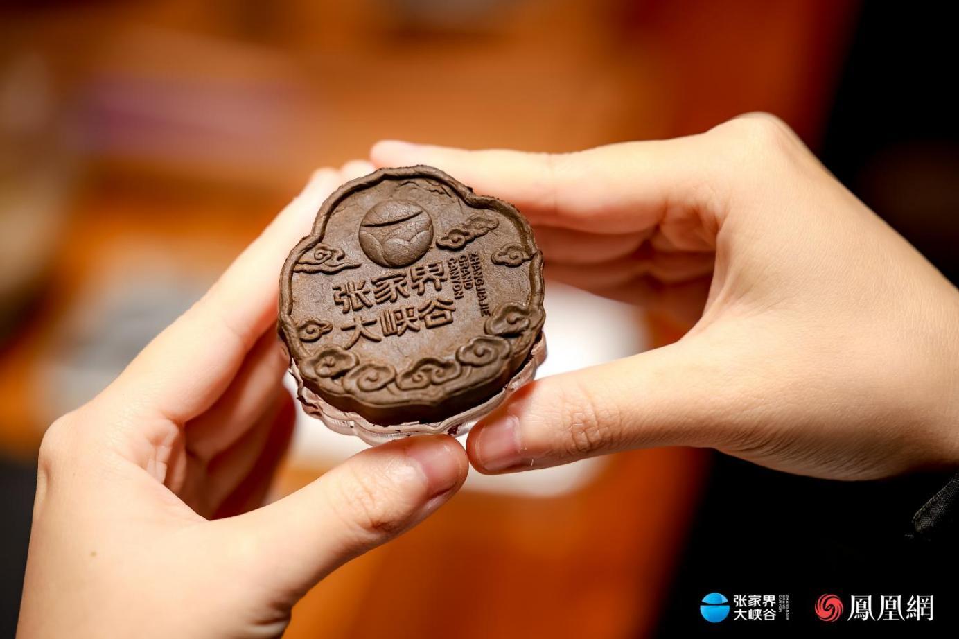 （罗子杰为张家界大峡谷设计的沉香牌饰品。）