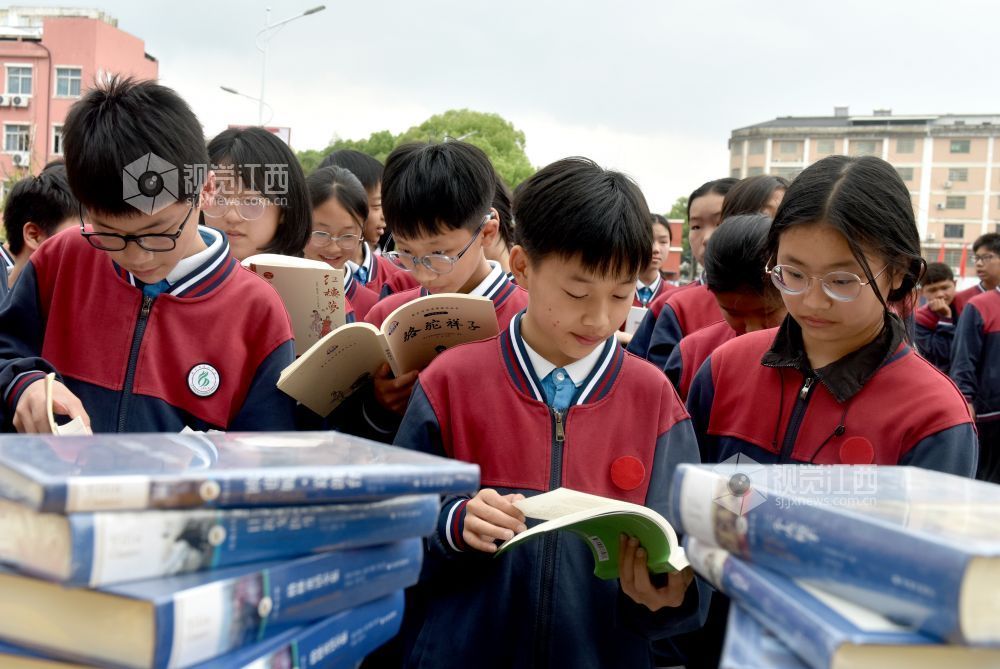 该校学生正在活动现场阅看自己喜欢的书籍。