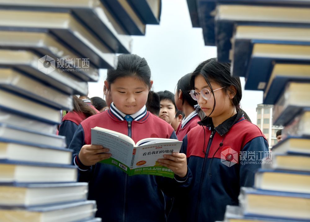 该校学生正在活动现场阅看自己喜欢的书籍。