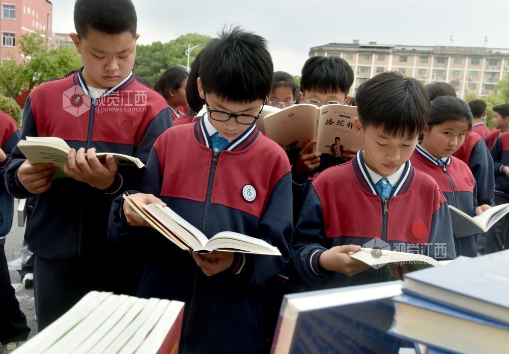 该校学生正在活动现场阅看自己喜欢的书籍。