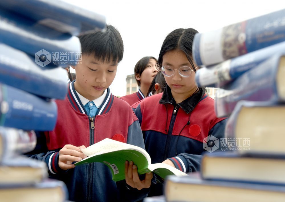该校学生正在活动现场阅看自己喜欢的书籍。
